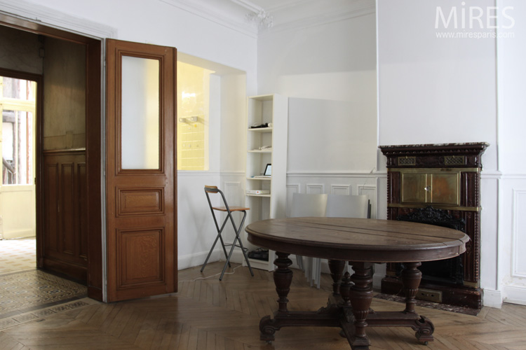 C0607 – Large round table, white paneled walls