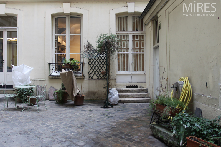 C0686 – Paved courtyard with table, fountain and potted plants