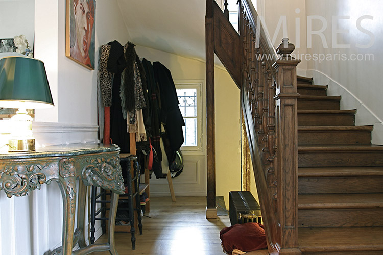 Crowded entrance and wooden staircase. C1152