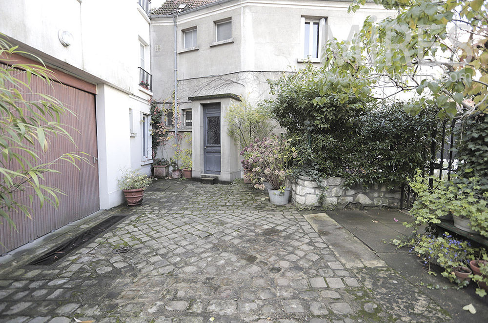 C1952 – Cour pavée avec garage